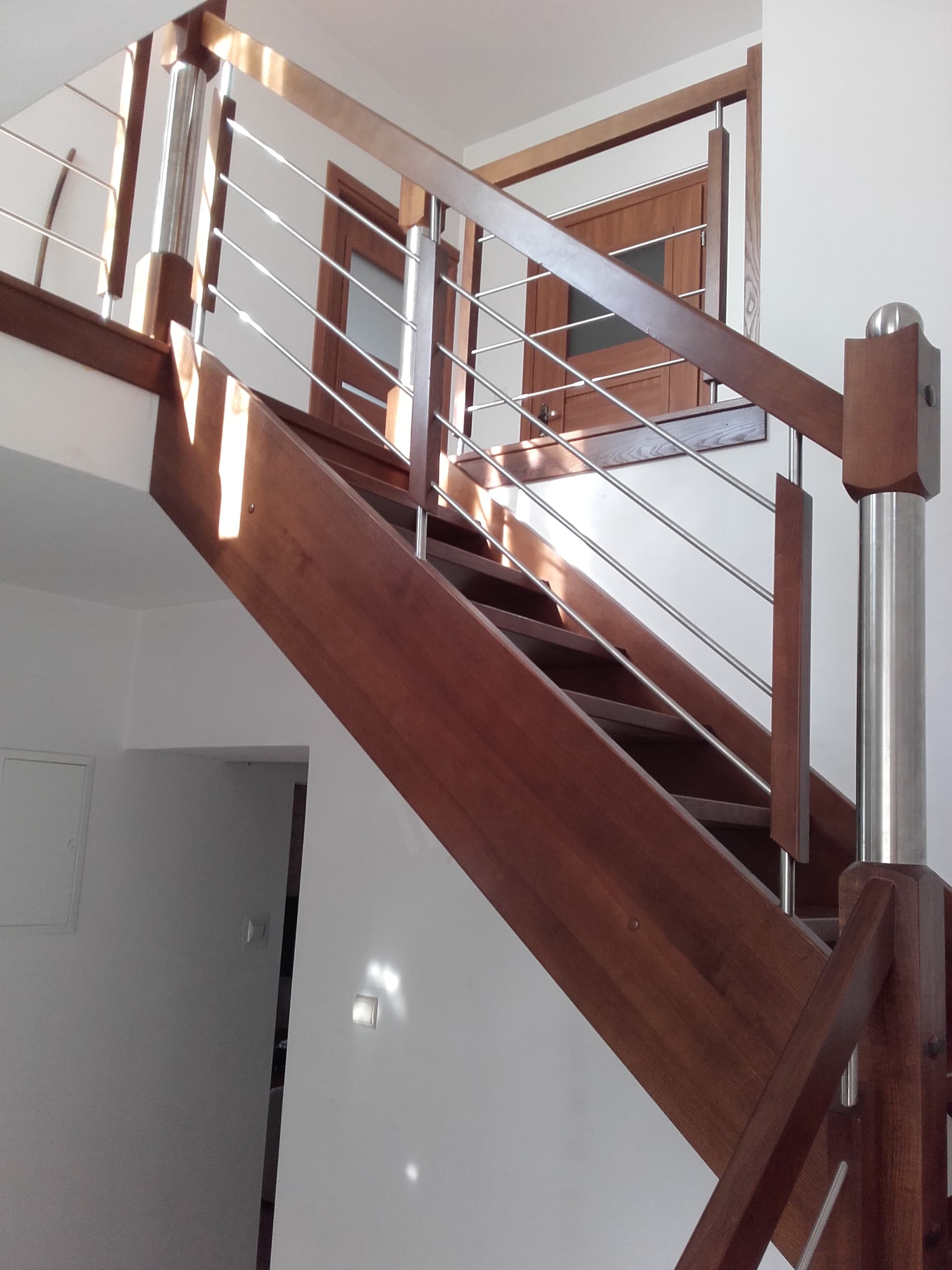 Schody drewniane z widocznymi stopniami i poręczą